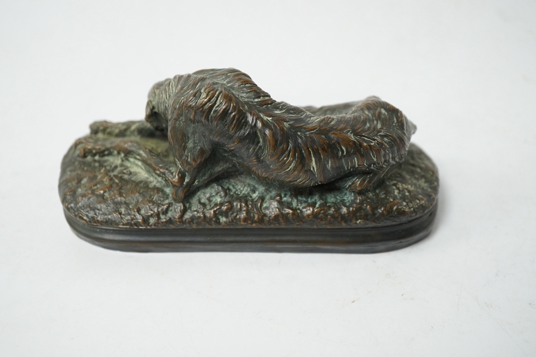 After Paul Joseph Raymond Gayrard (1807-1855), a small bronze of a deerhound in repose, 15cm wide. Condition - fair/good